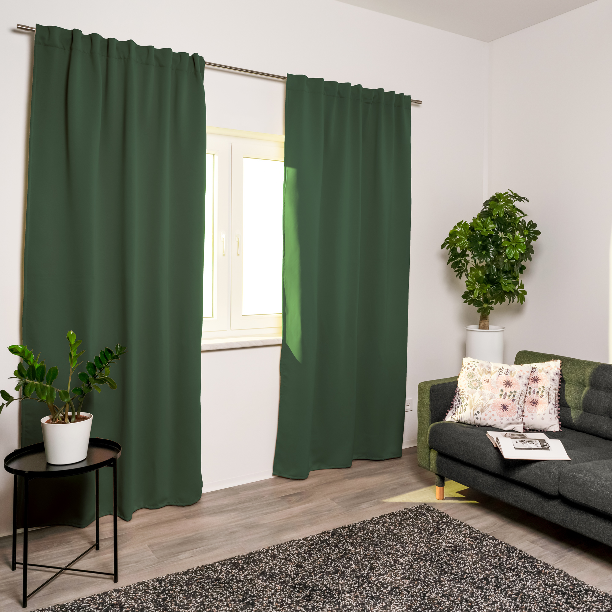Tenda acustica davanti a una finestra in un soggiorno moderno con divano e piante