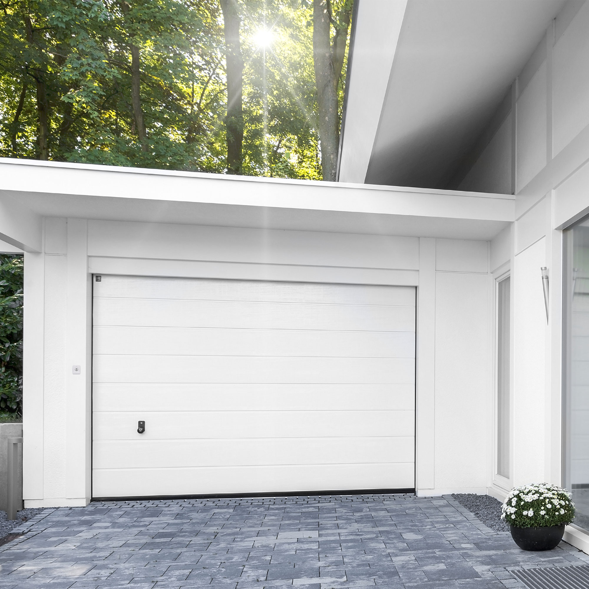 Porta del garage con interruttore per sistema di azionamento ML/JL, circondata da architettura moderna