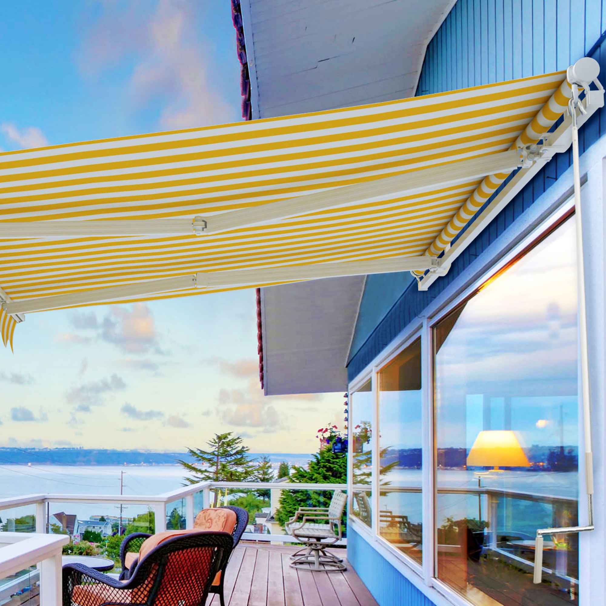 Terrazza con tenda da sole aperta, vista sul mare e case sullo sfondo