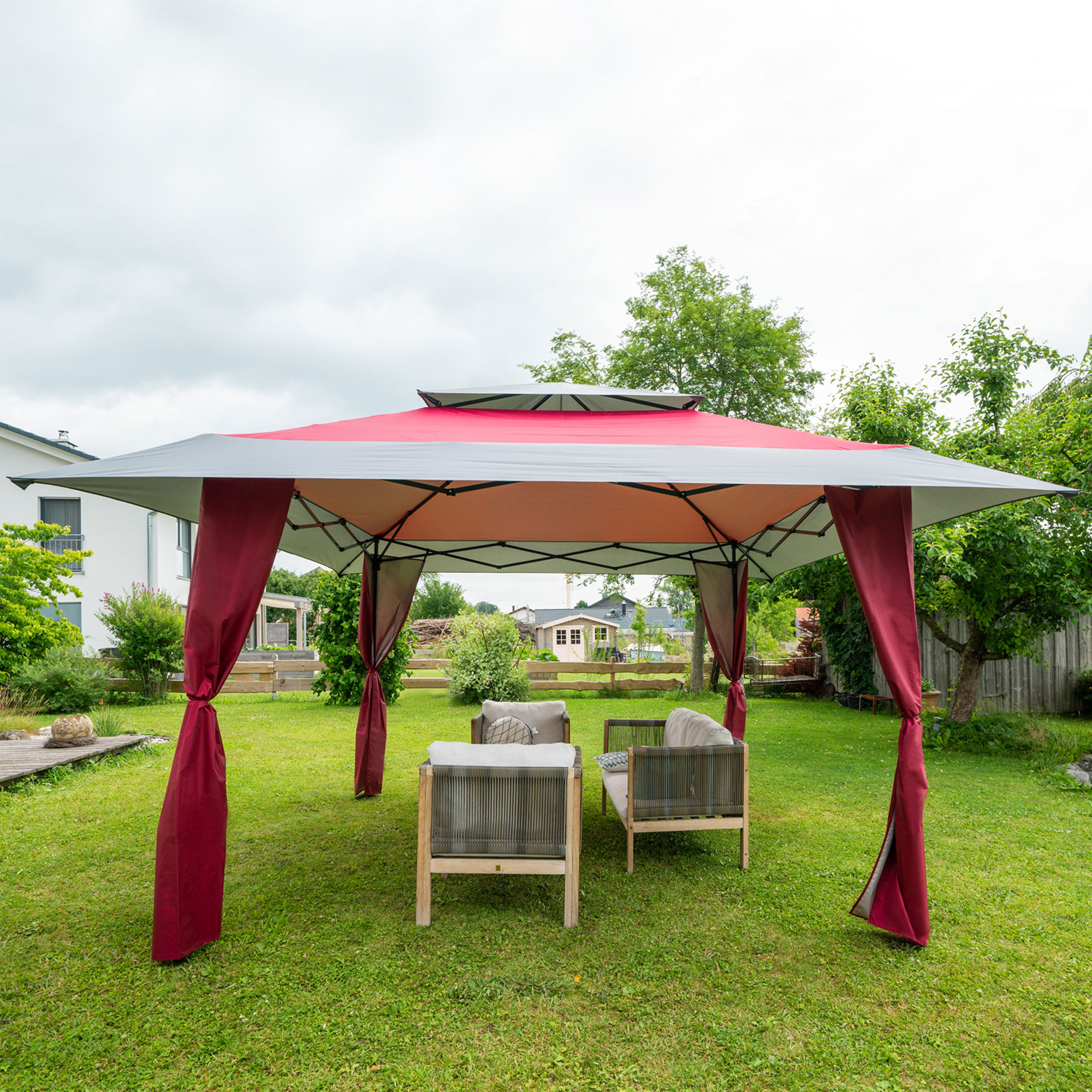 Struttura di gazebo pieghevole nel giardino con mobili da seduta sotto