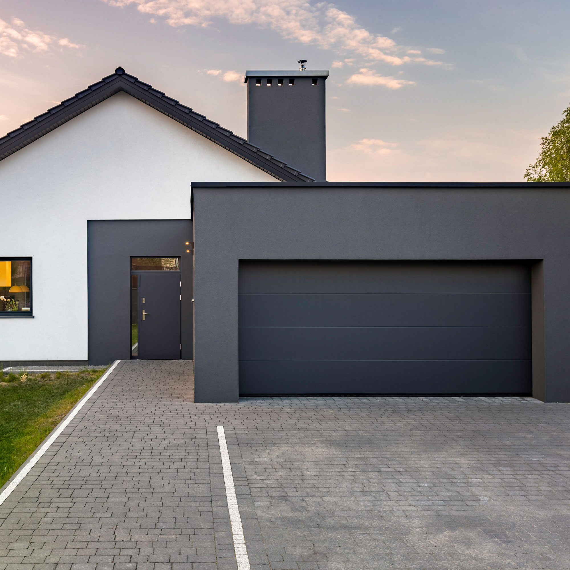 Casa moderna con tetto piano, garage e vialetto pavimentato