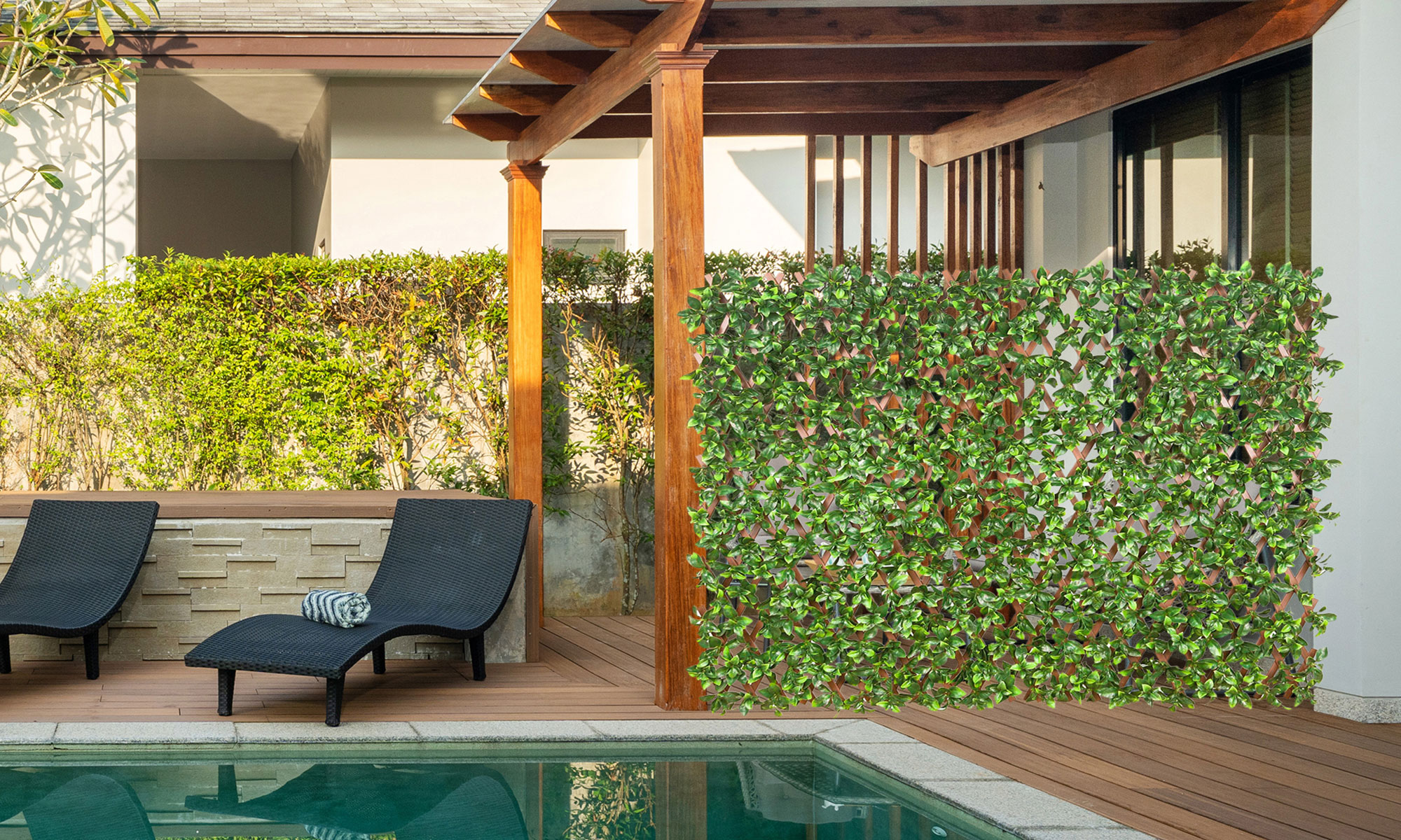 Persona rilassata in una vasca idromassaggio, parete di piante artificiali sullo sfondo, ambiente da giardino