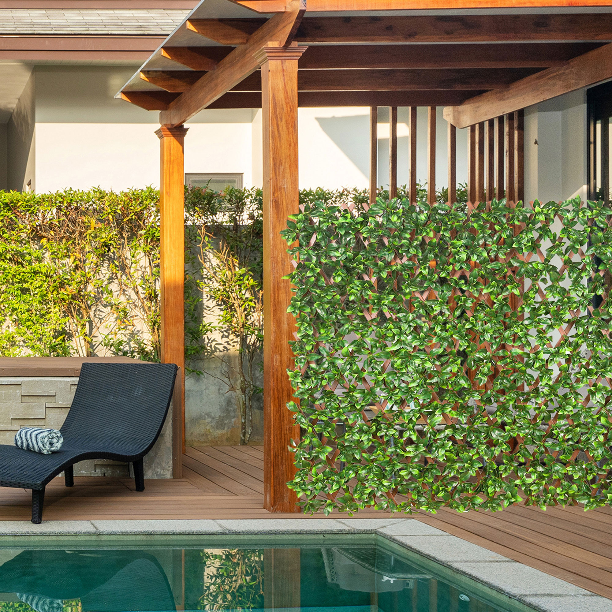 Persona rilassata in una vasca idromassaggio, parete di piante artificiali sullo sfondo, ambiente da giardino