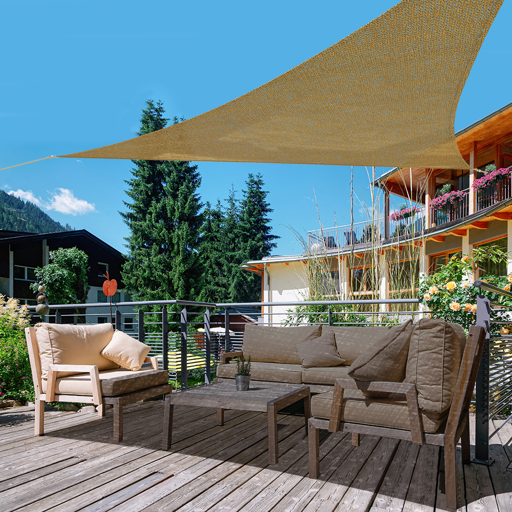Telo ombreggiante in HDPE traspirante sopra una terrazza con mobili e piante sullo sfondo