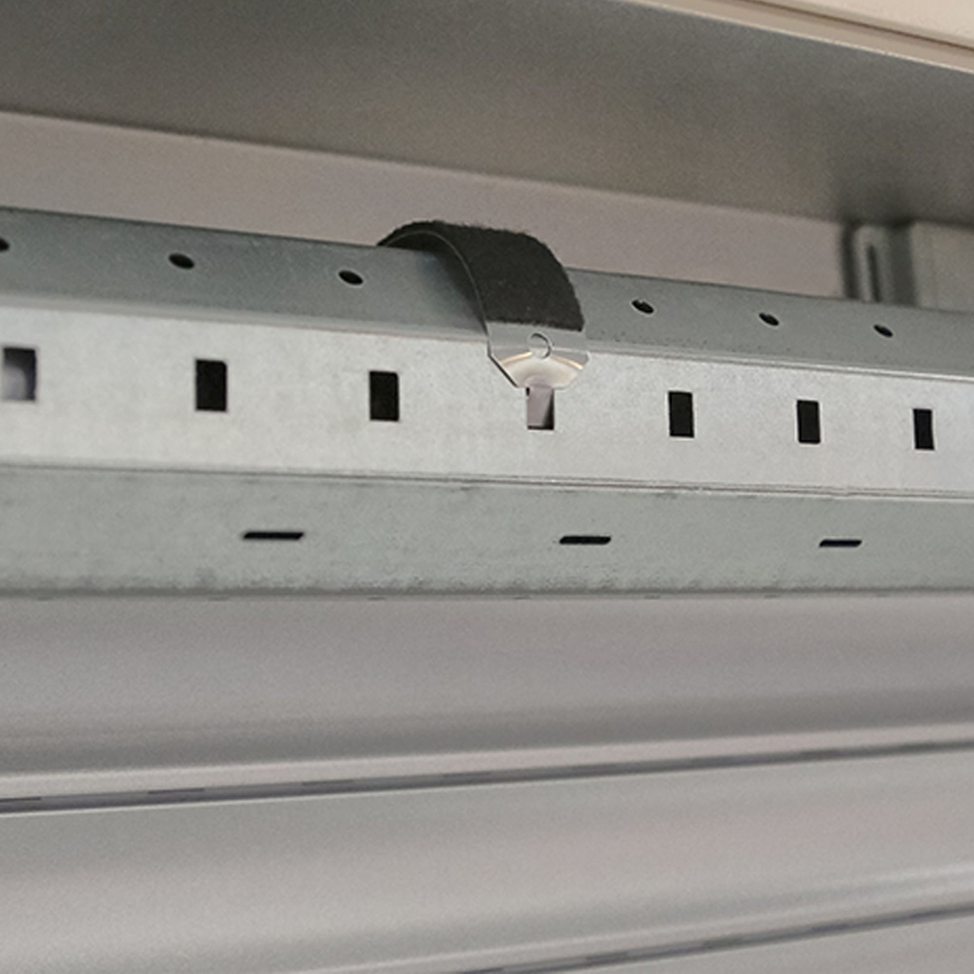 Gancio per nastro in acciaio con molla di sicurezza e protezione antigraffio fissato a una struttura metallica
