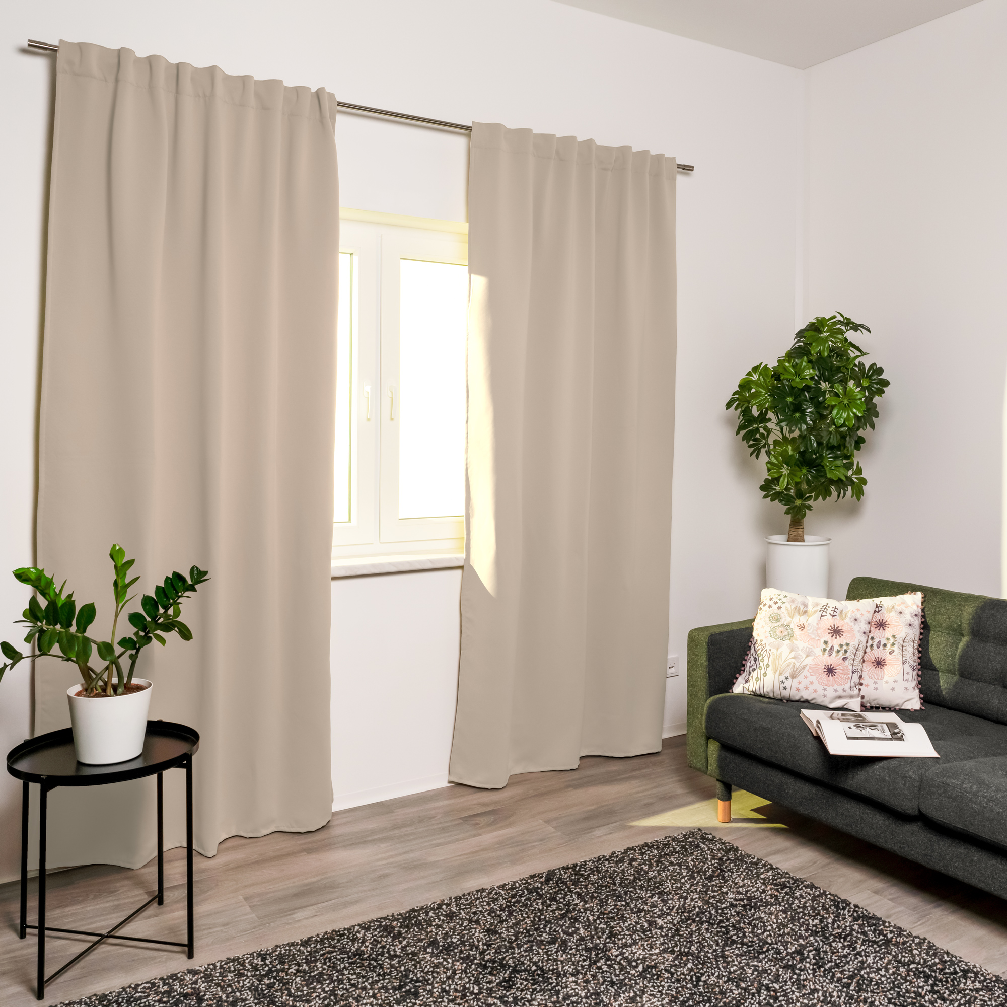 Tenda acustica con nastro combinato davanti a una finestra in un soggiorno moderno con piante e divano
