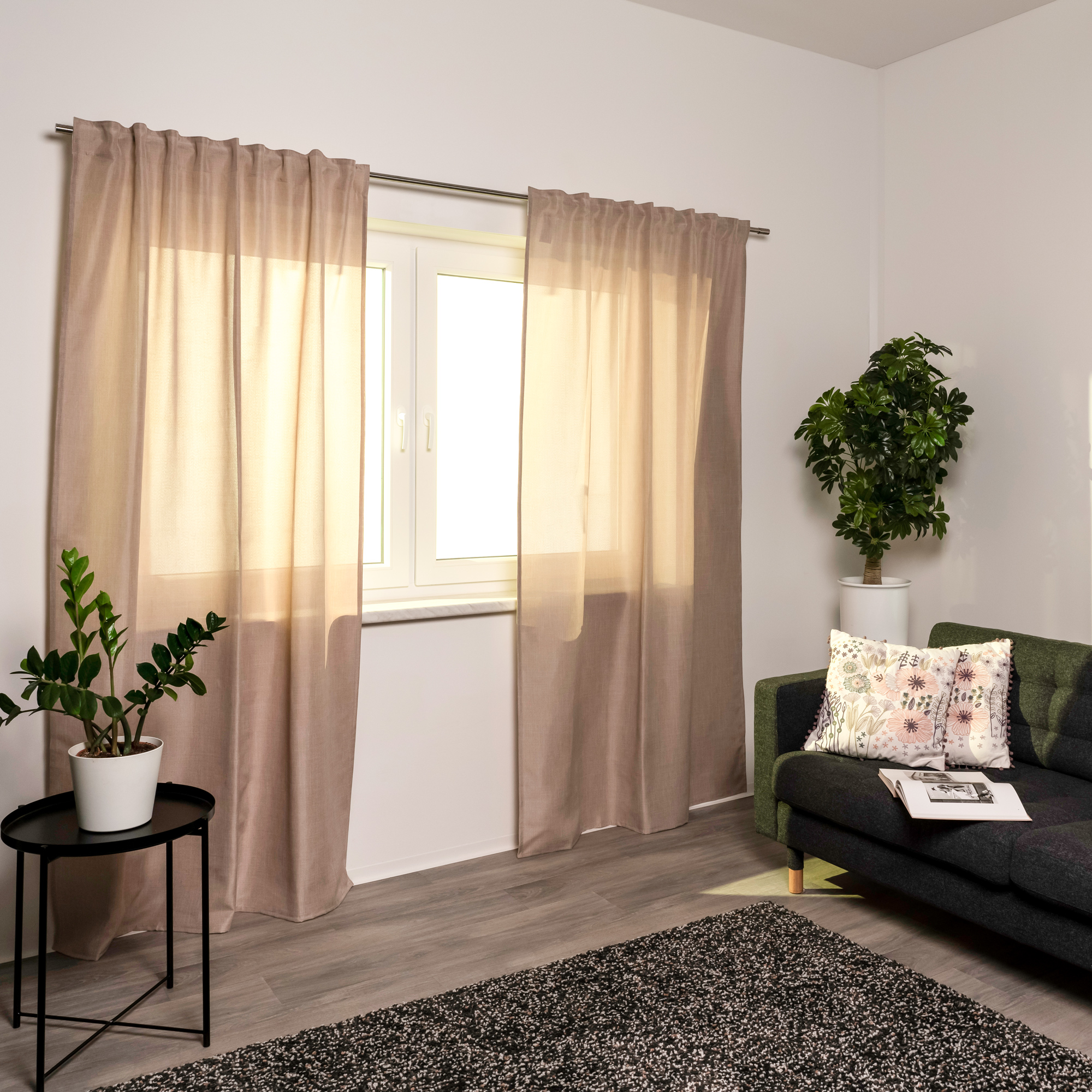 Tenda con nastro combinato davanti a una finestra in un soggiorno moderno con piante e divano