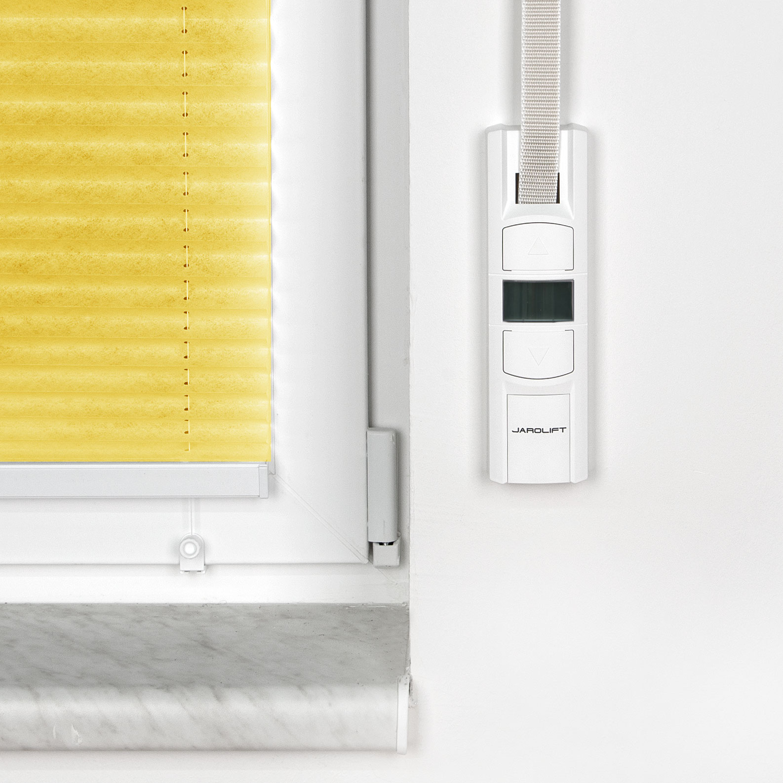 Avvolgitore elettrico JAROMAT Pro accanto a una finestra con tenda plissettata